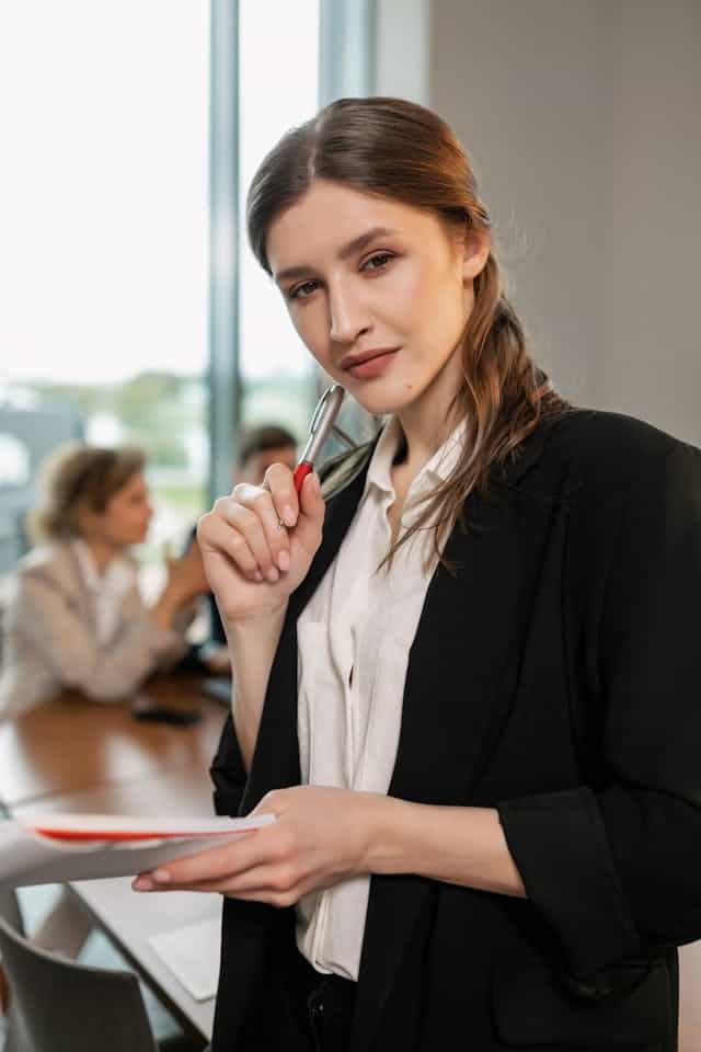 Business professional holding documents and a pen, representing confident oversight and coordination of vendor relationships.